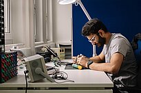 Studierender sitzt am Tisch und arbeitet